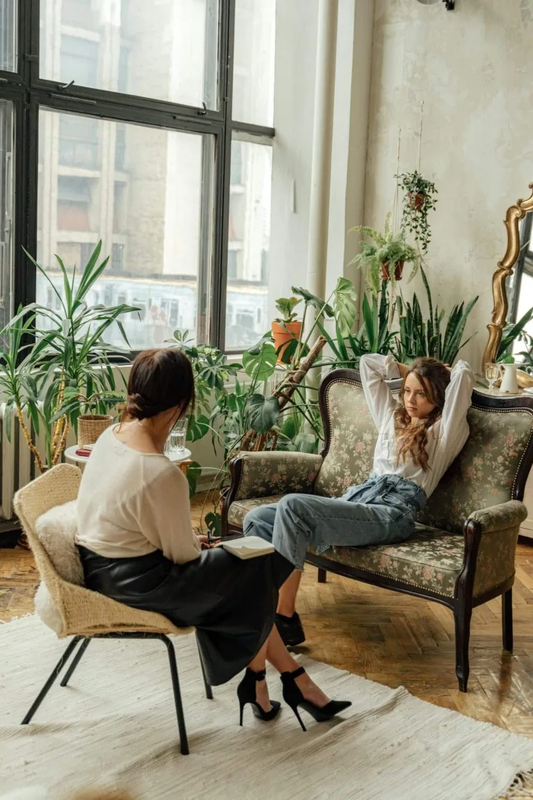 Client and therapist talking in a bright, plant-filled room