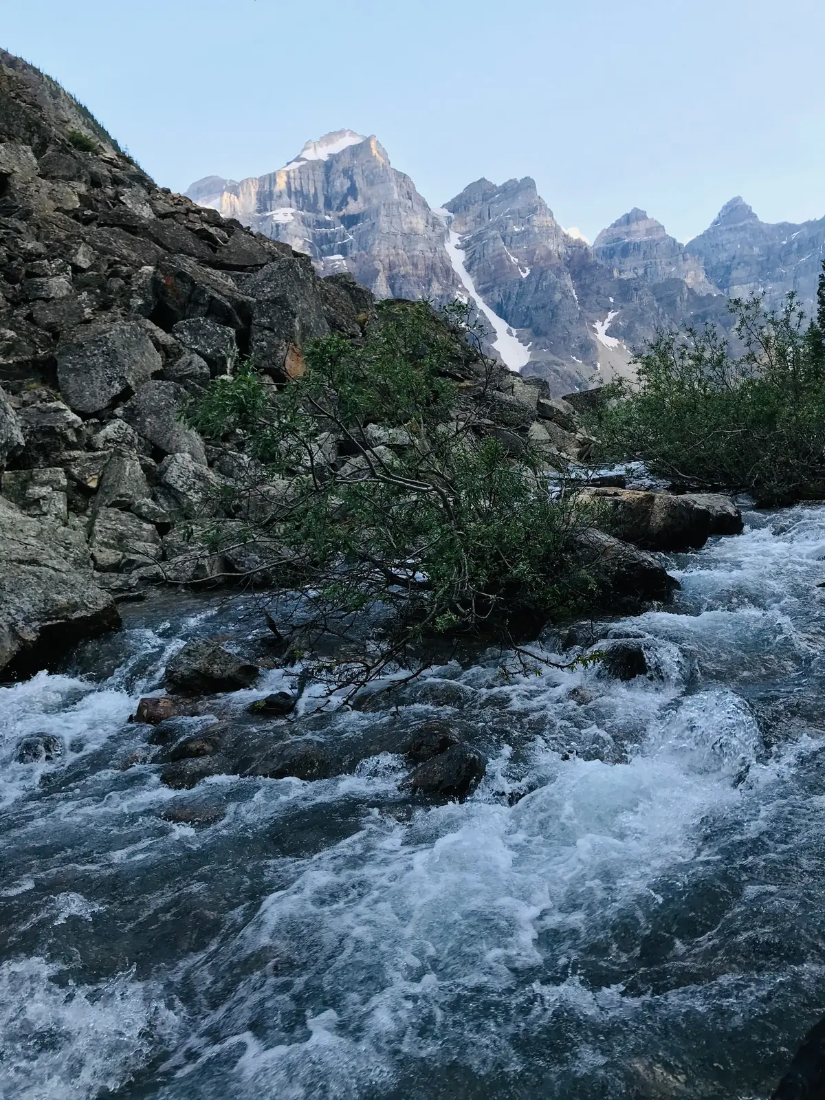 Rushing mountain river tumbling over rocks below snow-capped peaks