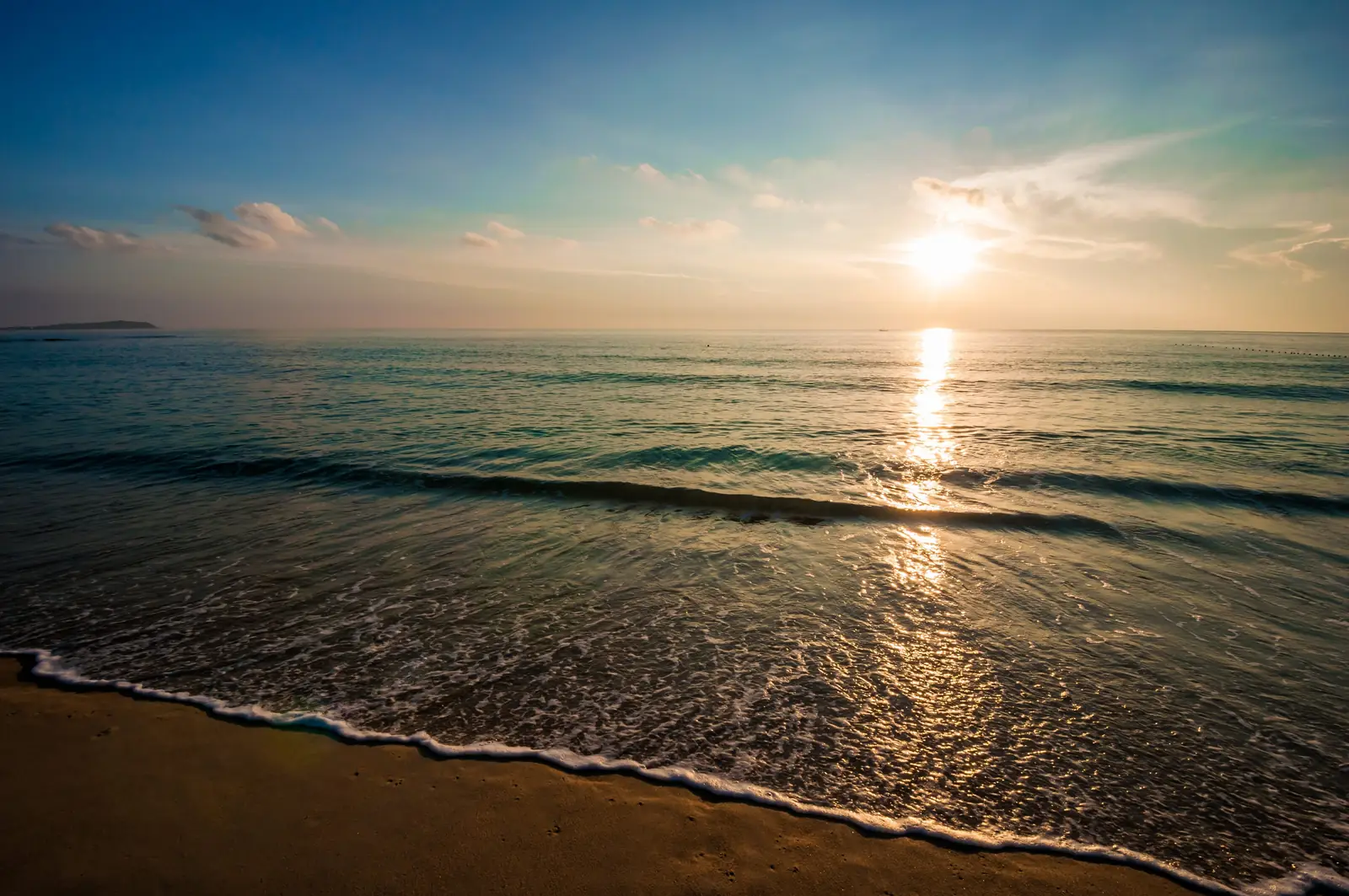 Calm sea at sunrise with gentle light on the water