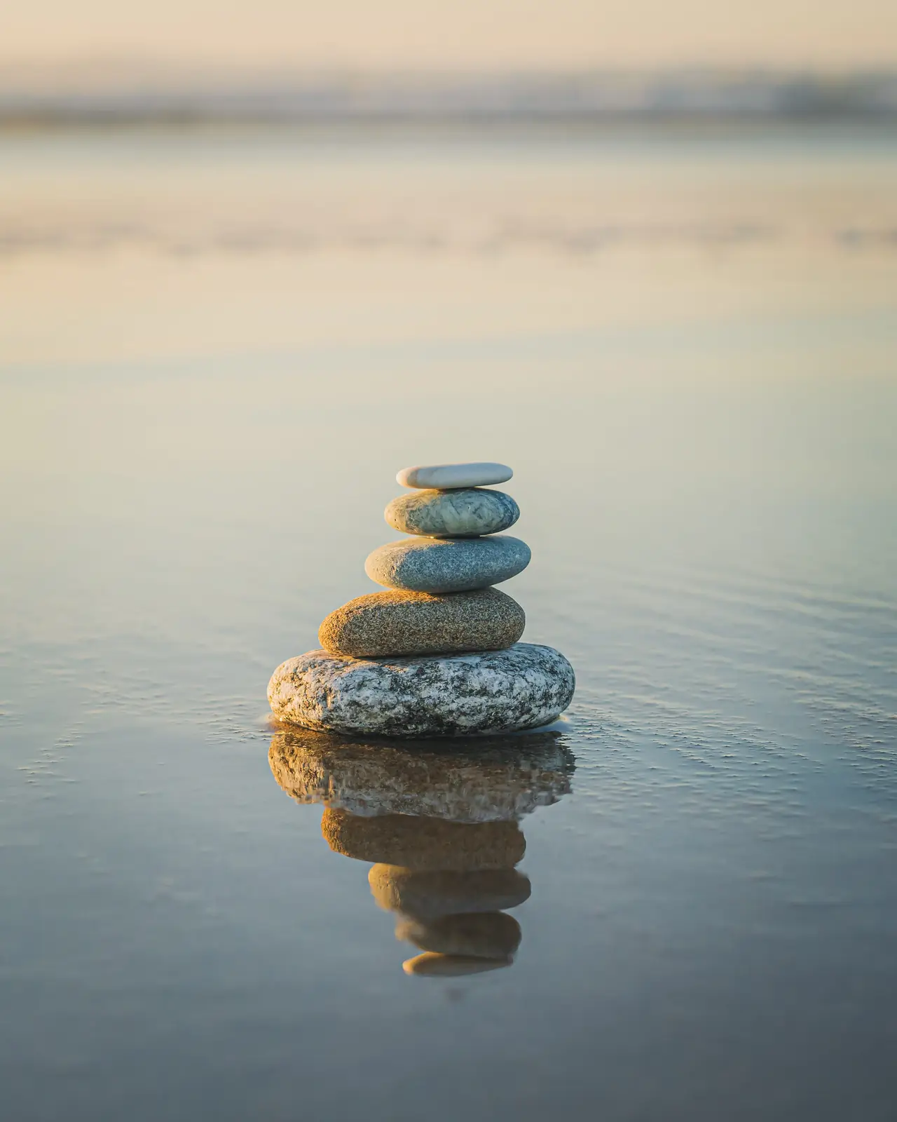 Balanced stones stacked beside a calm river