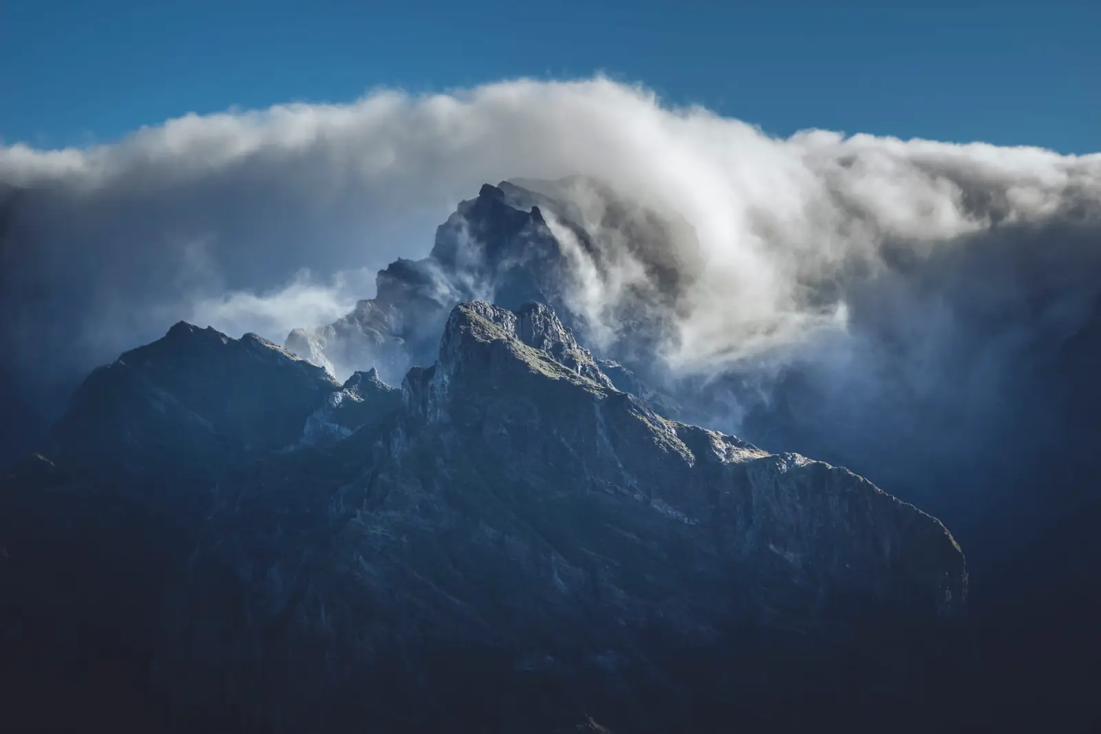 Storm clouds clearing from a mountain peak