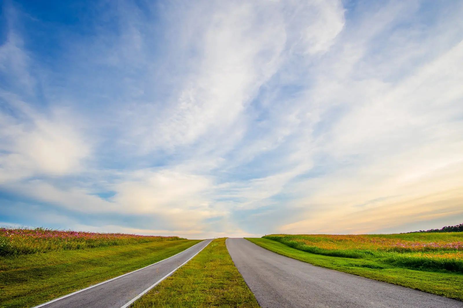 An open road stretching toward a wide prairie horizon